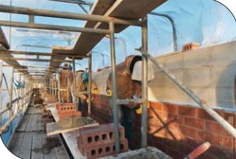 Enclosure and heating of work area to protect the materials, workers and installed masonry from severe cold weather